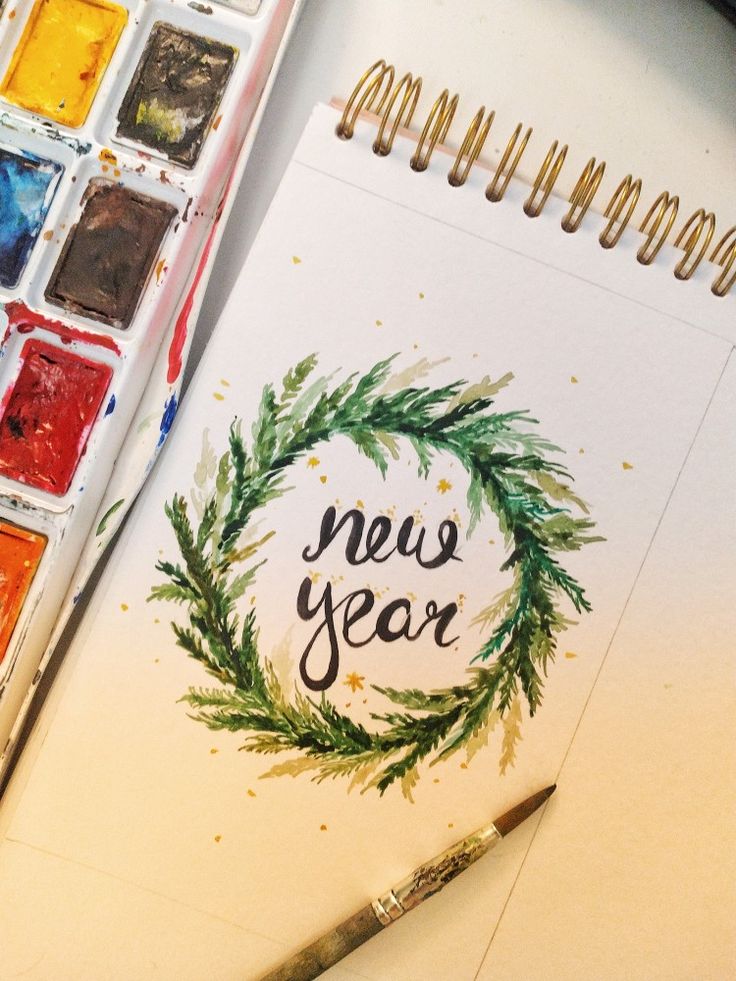 a watercolor and ink brush next to a new year's card