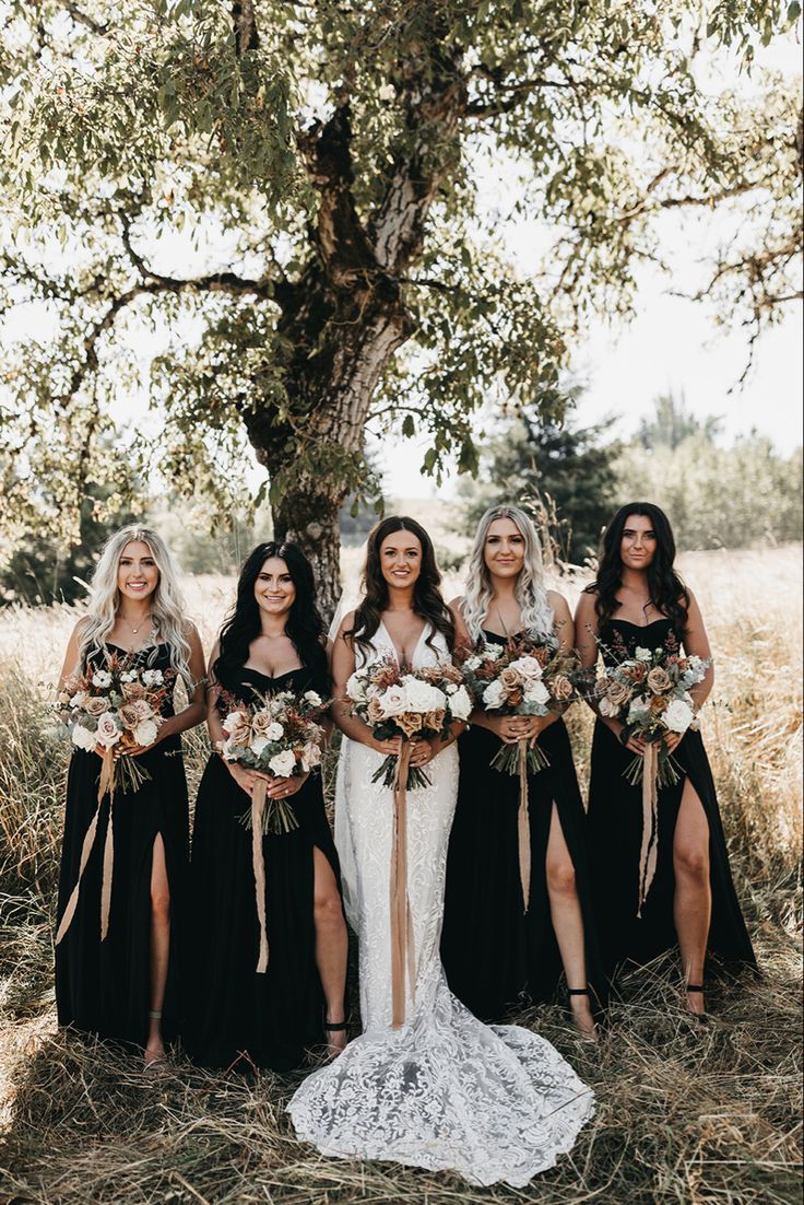 a group of women standing next to each other in front of a tree