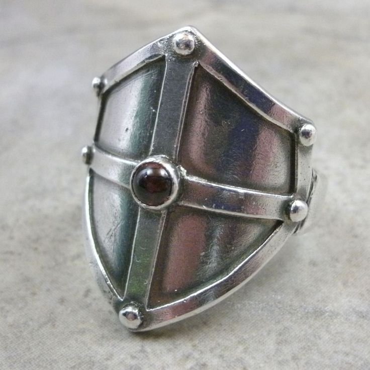 Shield ring is hand-crafted in .999 Fine Silver using Metal Clay. 4mm Cabochon stone is bezel set. If you would prefer a stone or ring size not listed in the drop-down menus please Contact Me for more information. Ring is MADE TO ORDER, so please allow 2-3 weeks for me to create it before shipping. (It usually takes less time than that, but I like to cover all the bases.) Ring comes boxed. Gift wrap is available at no additional charge upon request, just let me know in the "Add a Note" section a Medieval Shield, Silver Statement Jewelry, Medieval Shields, Armor Ring, 3d Ideas, Shield Ring, Magic Items, Fantasy Stuff, Fine Silver Jewelry