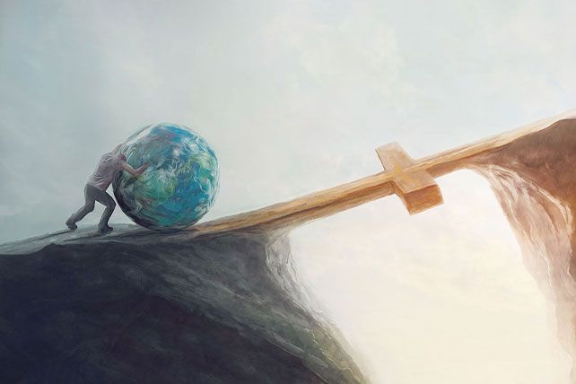 a man holding a wooden cross on top of a cliff with a world in the background