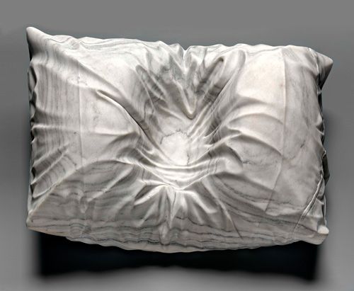 a white pillow that has been made to look like an abstract piece of cloth on it