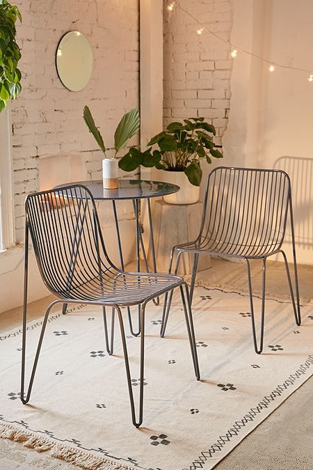 two chairs sitting on top of a rug next to a table with a potted plant