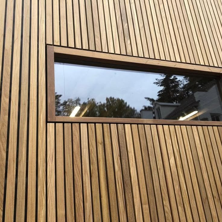 there is a window on the side of a building that has wood slats in it