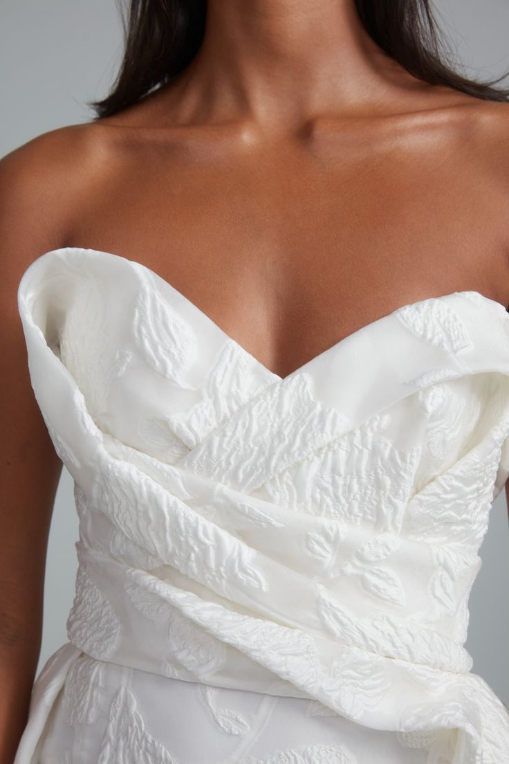 a woman wearing a strapless white wedding dress