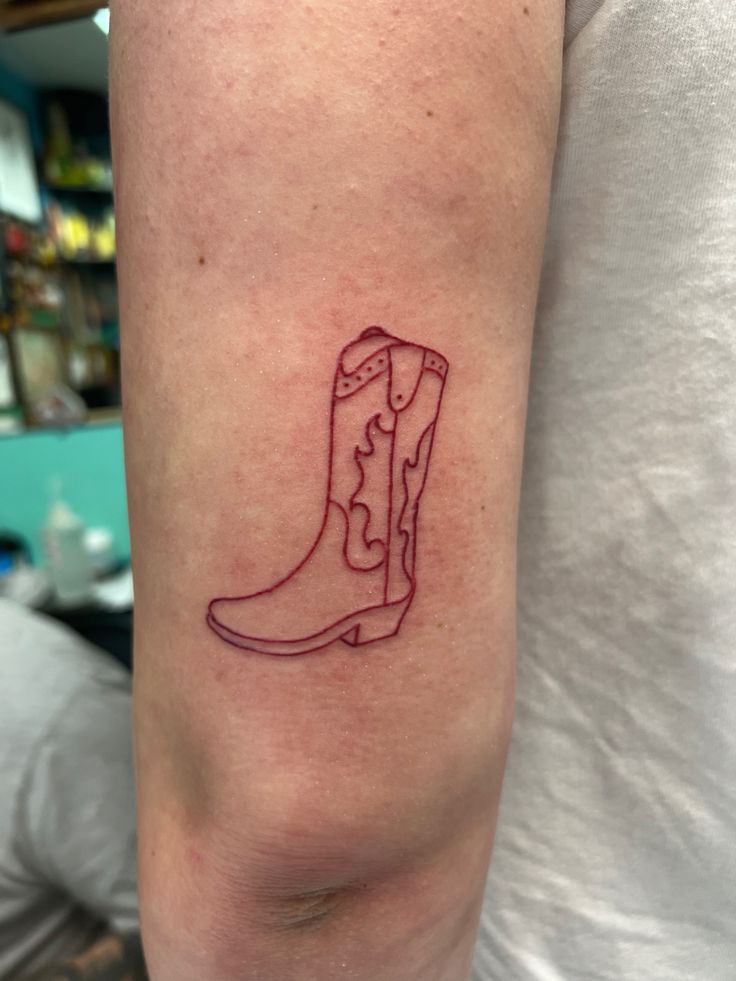 a tattoo on the arm of a person with a cowboy boot