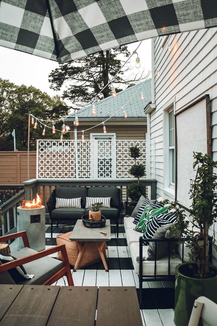 an outdoor living area with patio furniture and lights