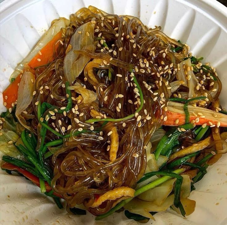 a white plate topped with veggies covered in sesame seeds