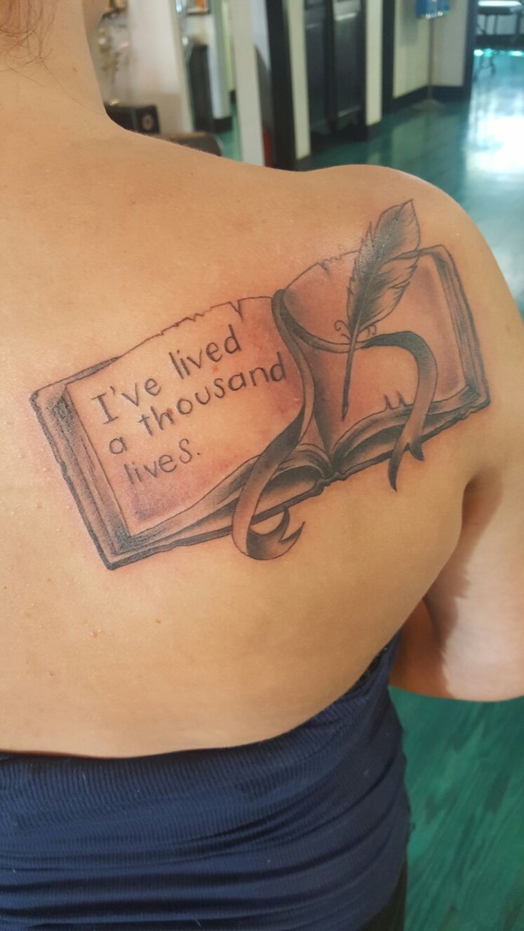 a woman with a book tattoo on her back shoulder and the words i've lived a thousand lives