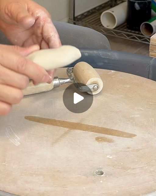 a person is making something on top of a wooden table with a rolling pin in front of it