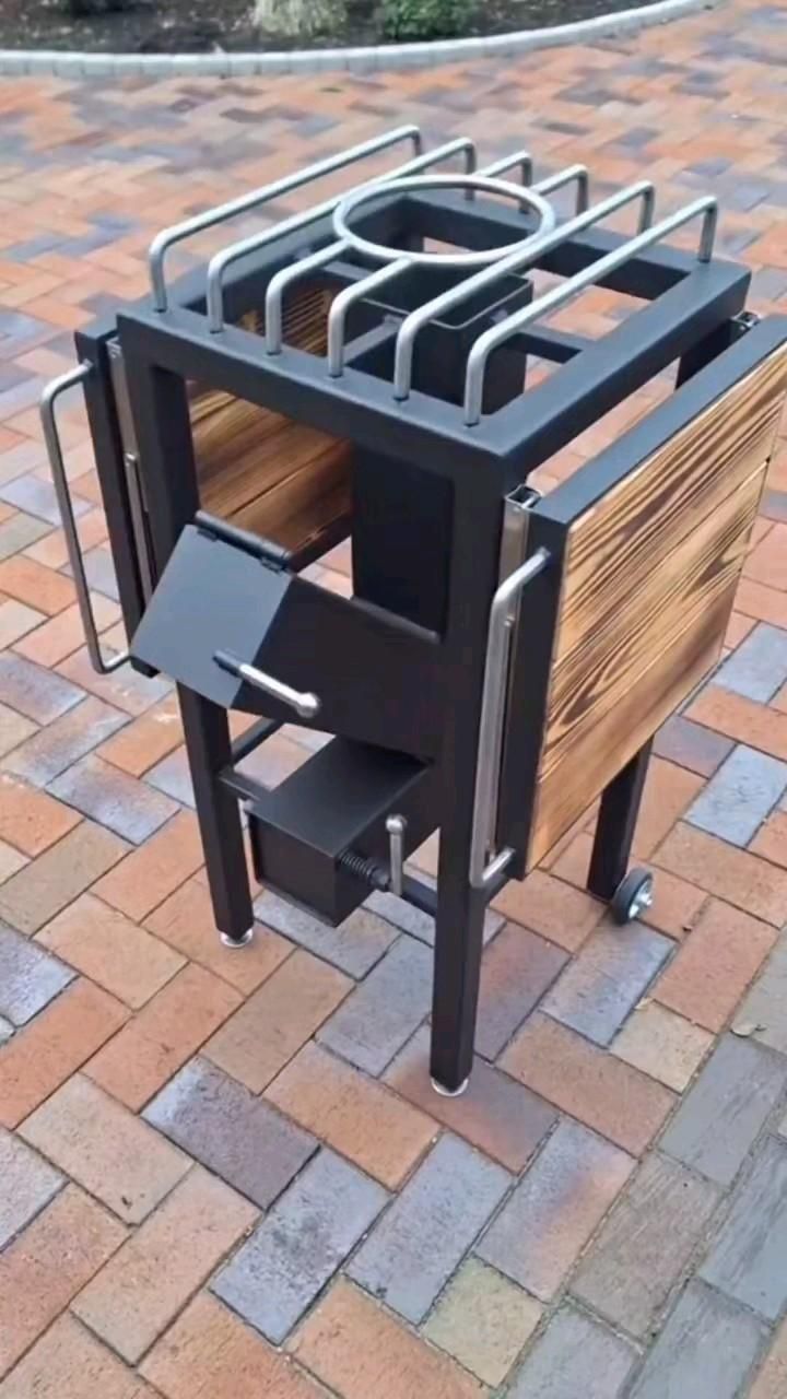 an outdoor table made out of wood and metal on brick walkway with small potted planter in the center