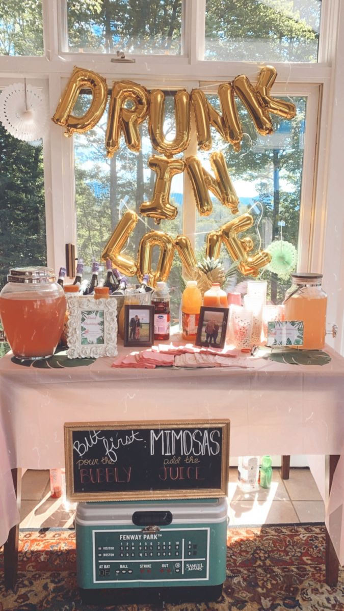 a party table with balloons and drinks on it in front of a large sign that says drunk time