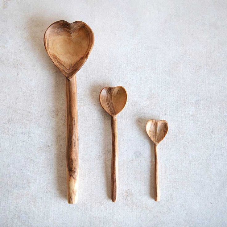 three wooden spoons and two heart shaped spoons