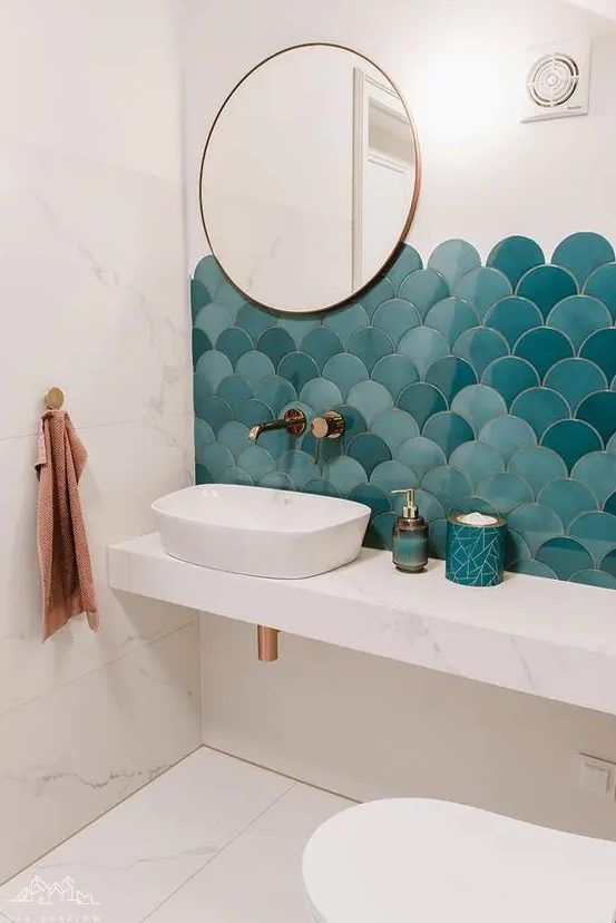 a bathroom with two sinks, a mirror and a blue scallop tile backsplash