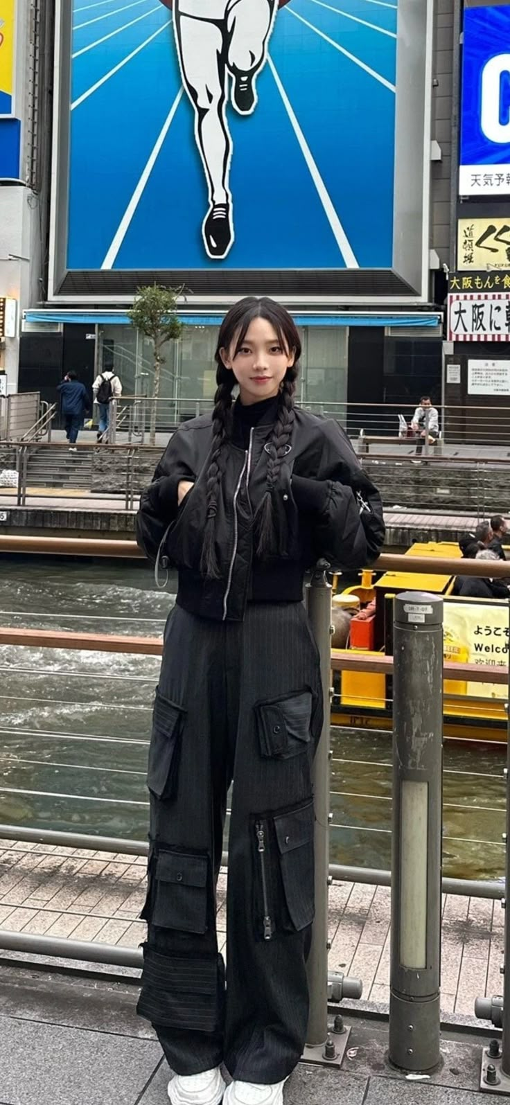 a woman standing in front of a large billboard