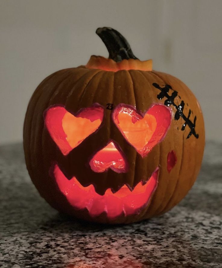 a carved pumpkin with hearts on it