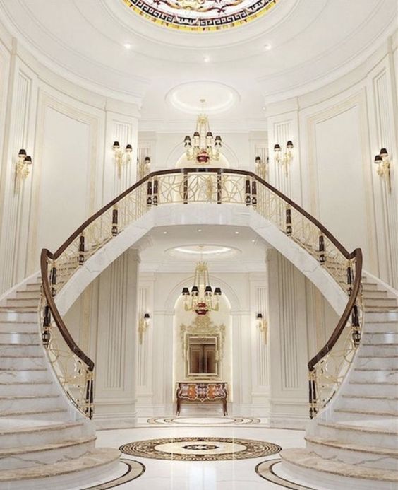 an ornate staircase in the middle of a white room with chandelier and stained glass window