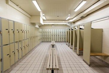 a long row of lockers in a large room with white tiles on the floor