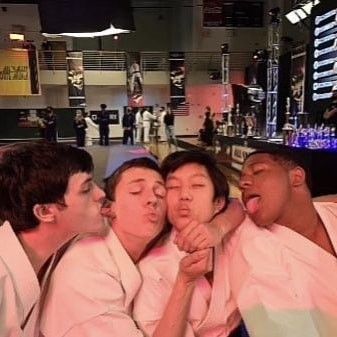 four people in white kimonos are posing for the camera with their mouths open