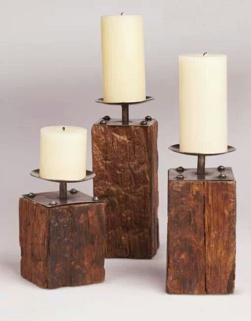 three wooden candle holders with white candles on them