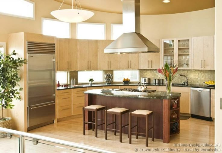 a large kitchen with an island in the middle and two stools on the side