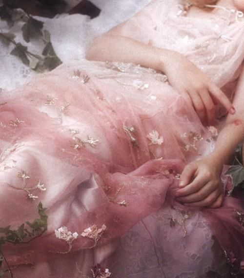 a woman in a pink dress laying down