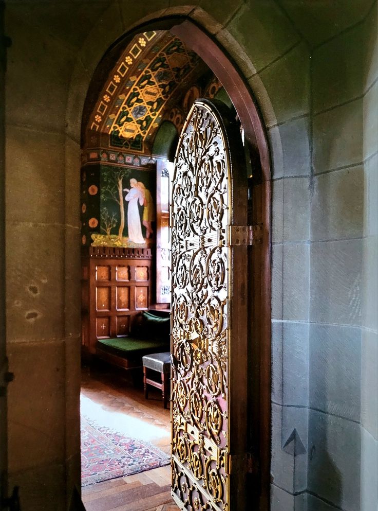 an open door leading into a room with wooden floors and walls, decorated in intricate designs