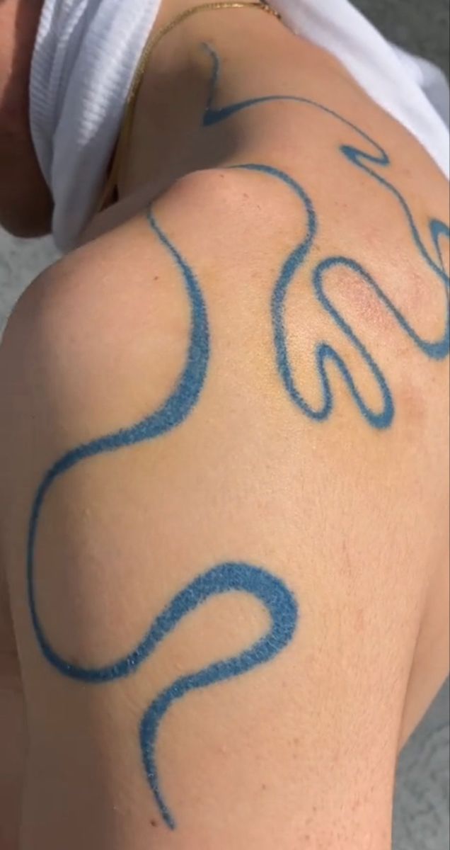 the back of a man's arm with blue ink on it