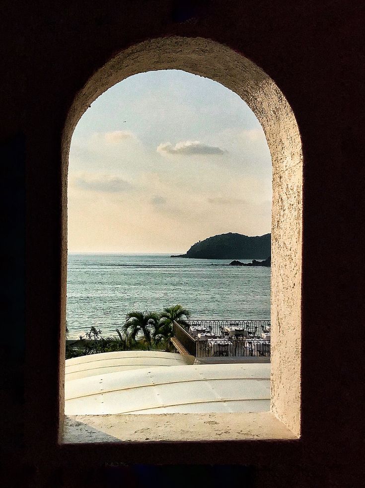 an arched window overlooking the ocean and beach