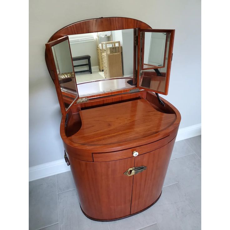 an oval shaped wooden vanity with mirror on top