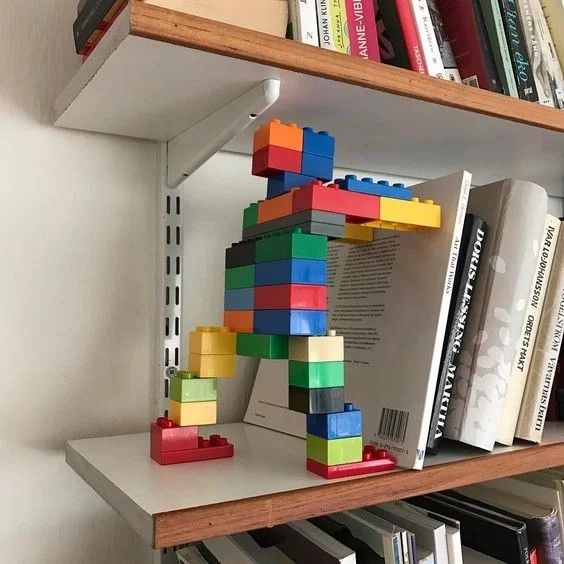 a book shelf filled with books and legos on top of eachother's shelves