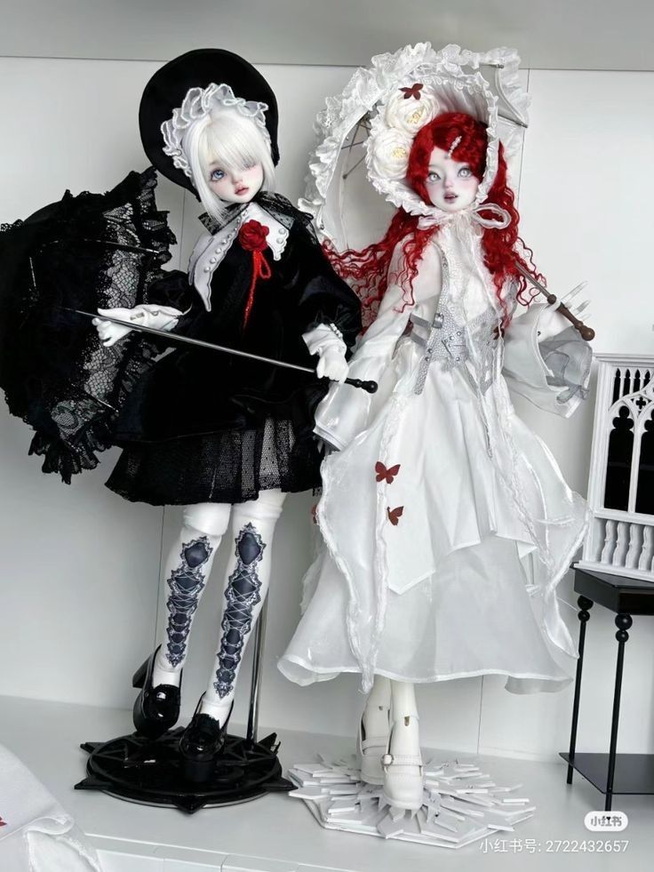 two dolls are dressed in black and white