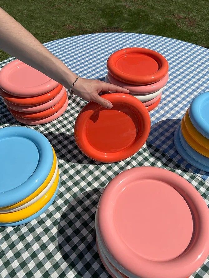 a table topped with plates and bowls on top of a checkered cloth