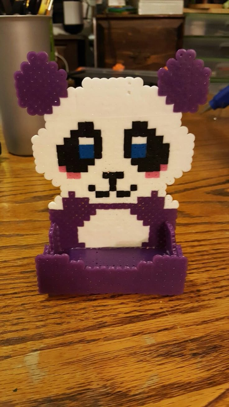 a toy panda bear sitting on top of a wooden table