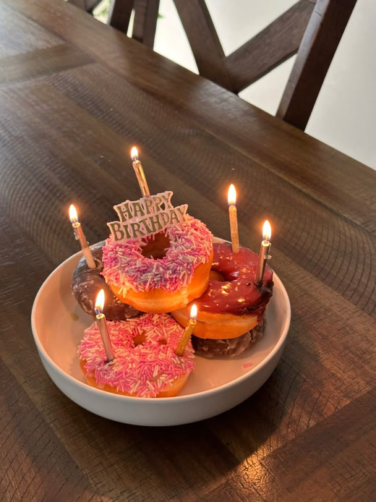 a plate with donuts and candles sitting on a table