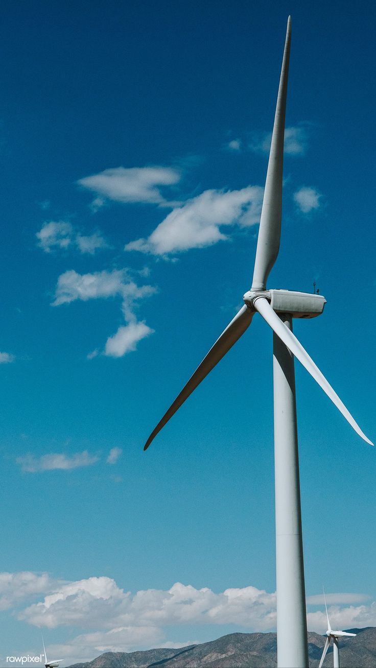 several wind turbines are shown against a blue sky