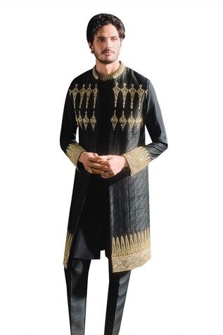 Black longline bundi with trikone border framing the hem and  lines running across the body with ornate linear motifs crowning the bundi. Paired with an inner embellished kurta and pant. - Aza Fashions Ceremonial Fitted Sherwani With Embroidered Border, Black Nehru Jacket With Zari Work For Ceremonial Occasions, Ceremonial Black Nehru Jacket With Zari Work, Black Nehru Jacket For Ceremonial Transitional Events, Transitional Black Nehru Jacket For Ceremonial Occasions, Traditional Bandhgala With Stand Collar For Ceremonial Occasions, Black Kurta With Gold Embroidery For Ceremonial Occasions, Traditional Bandhgala With Stand Collar, Traditional Ceremonial Bandhgala With Stand Collar