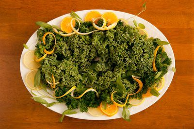 a white plate topped with broccoli covered in orange peels and lemon slices