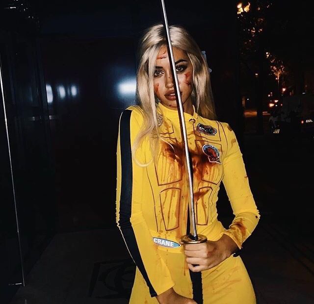 a woman dressed in yellow holding an umbrella