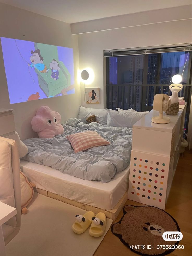 a bed room with a large screen on the wall