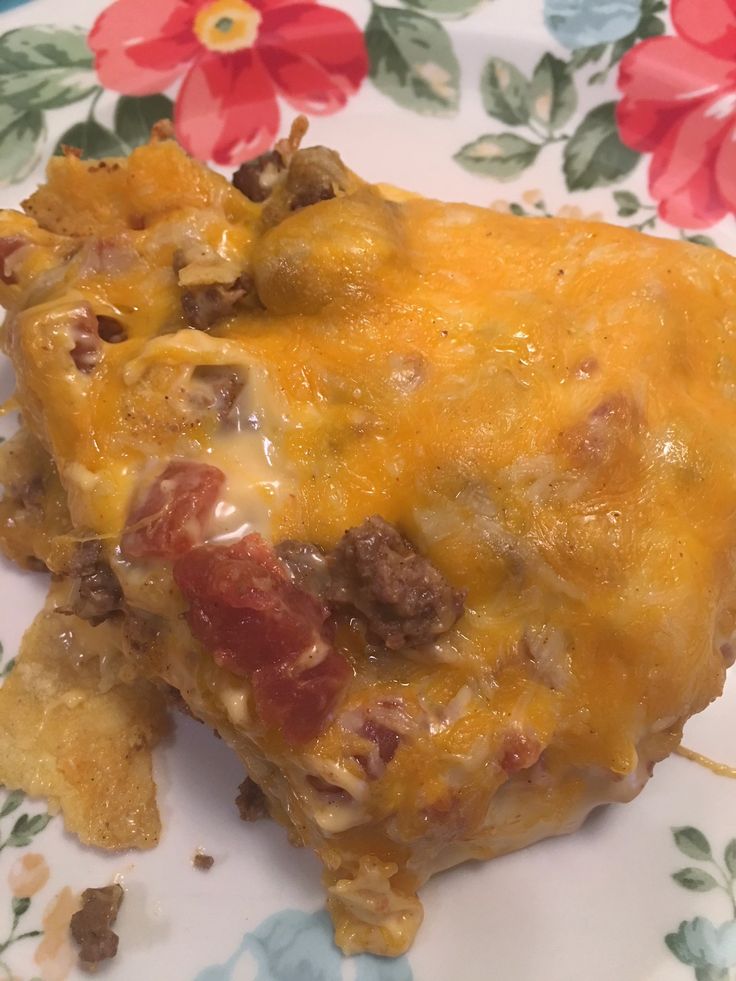 a piece of cheesy taco casserole on a flowered plate