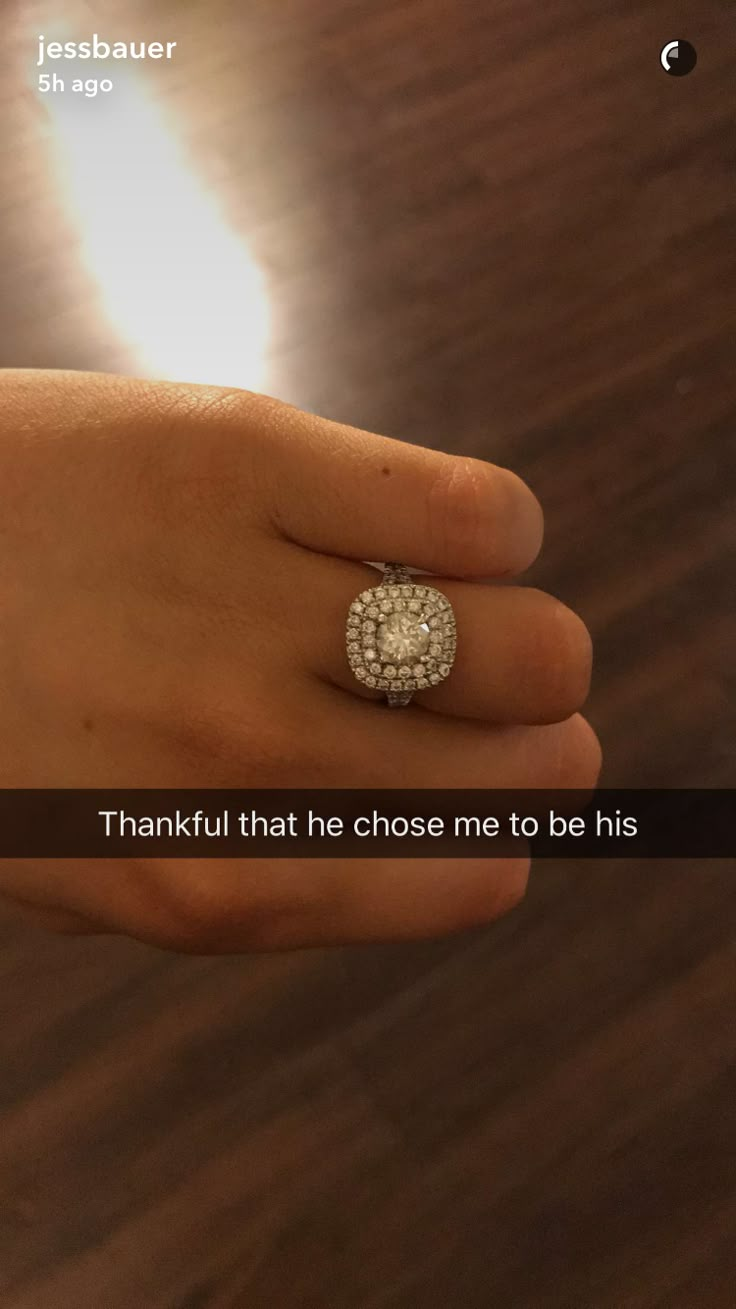 a person's hand with a diamond ring on it