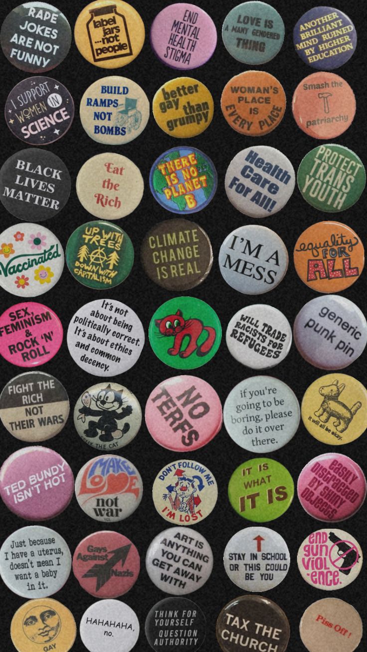 many different colored buttons are arranged on a black surface with words written below them, all in various sizes and shapes