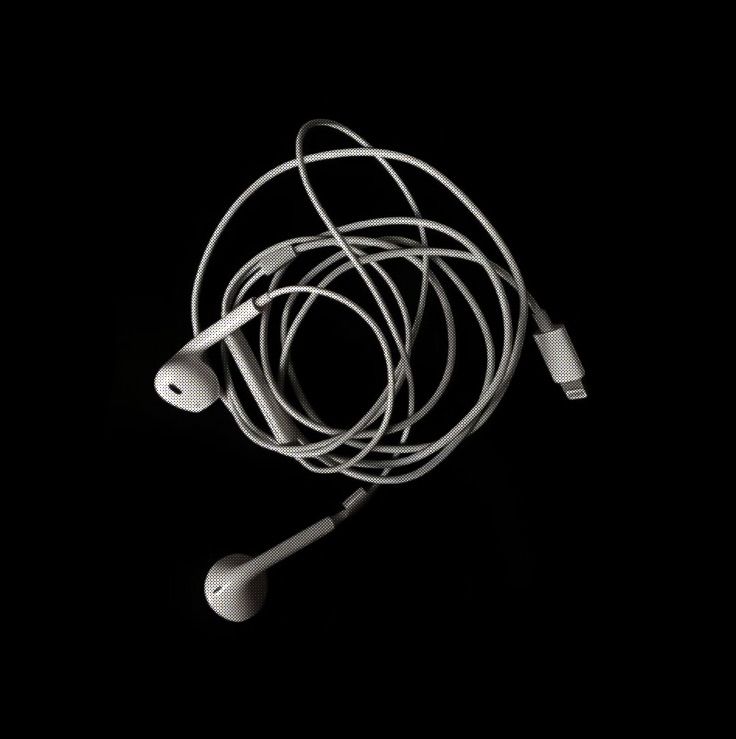 an earbud is laying on the ground in the dark with wires attached to it