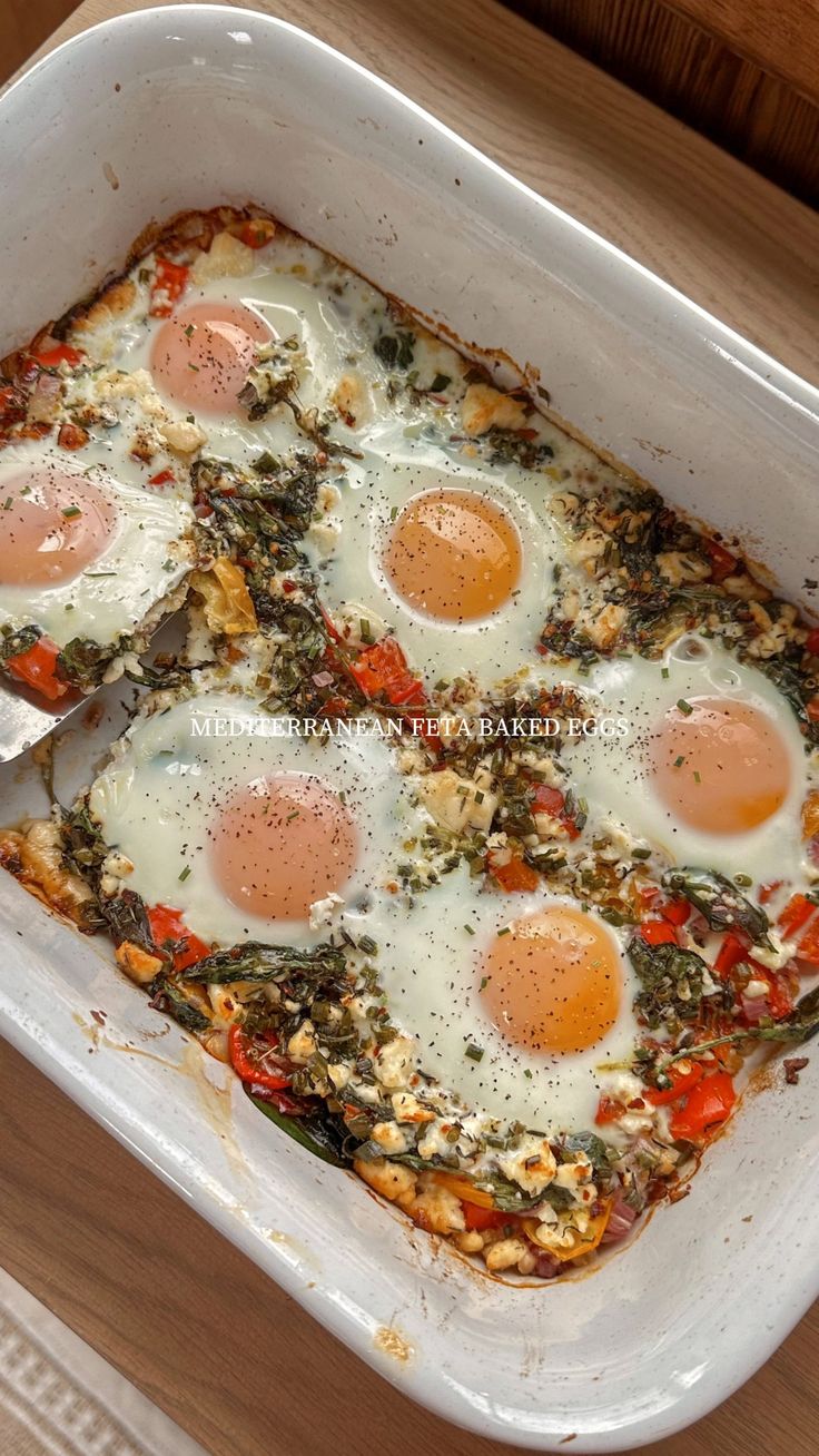 an egg dish in a white casserole dish on a wooden table