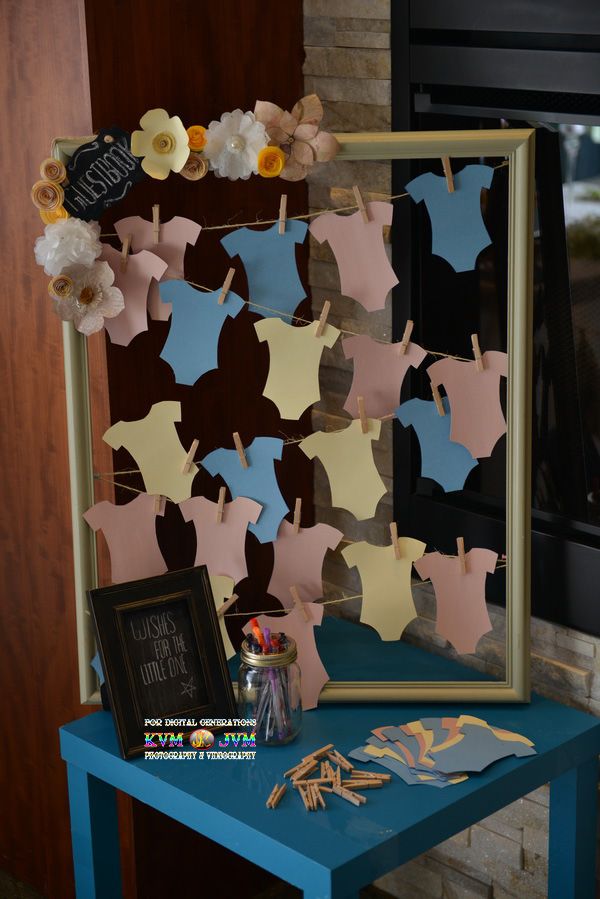 a blue table topped with clothes and flowers next to a framed photo on the wall