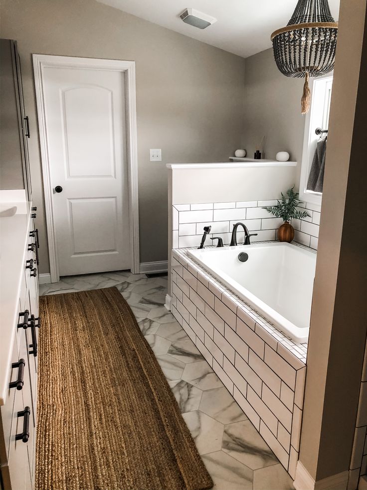 a bathroom with a bathtub and rug on the floor in front of a door