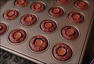 chocolate cupcakes in a muffin tin ready to be baked into the oven