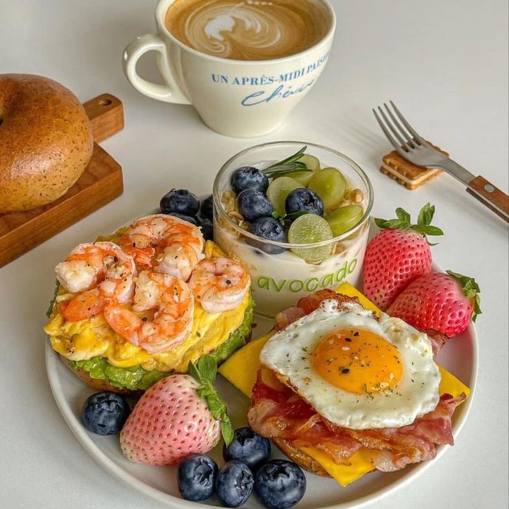 a white plate topped with breakfast foods next to a cup of cappuccino