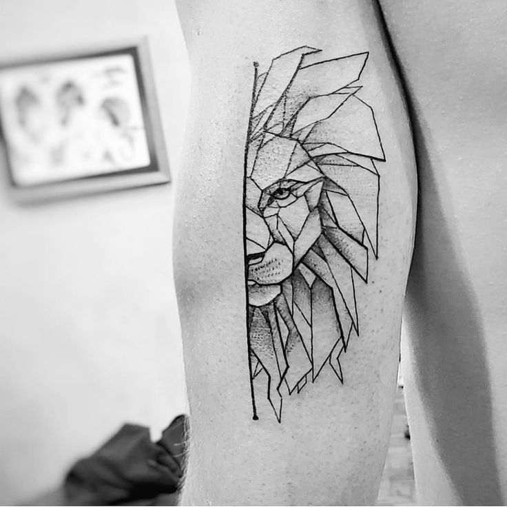 a black and white photo of a man's arm with a lion tattoo on it