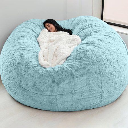 a woman laying in a large blue bean bag chair